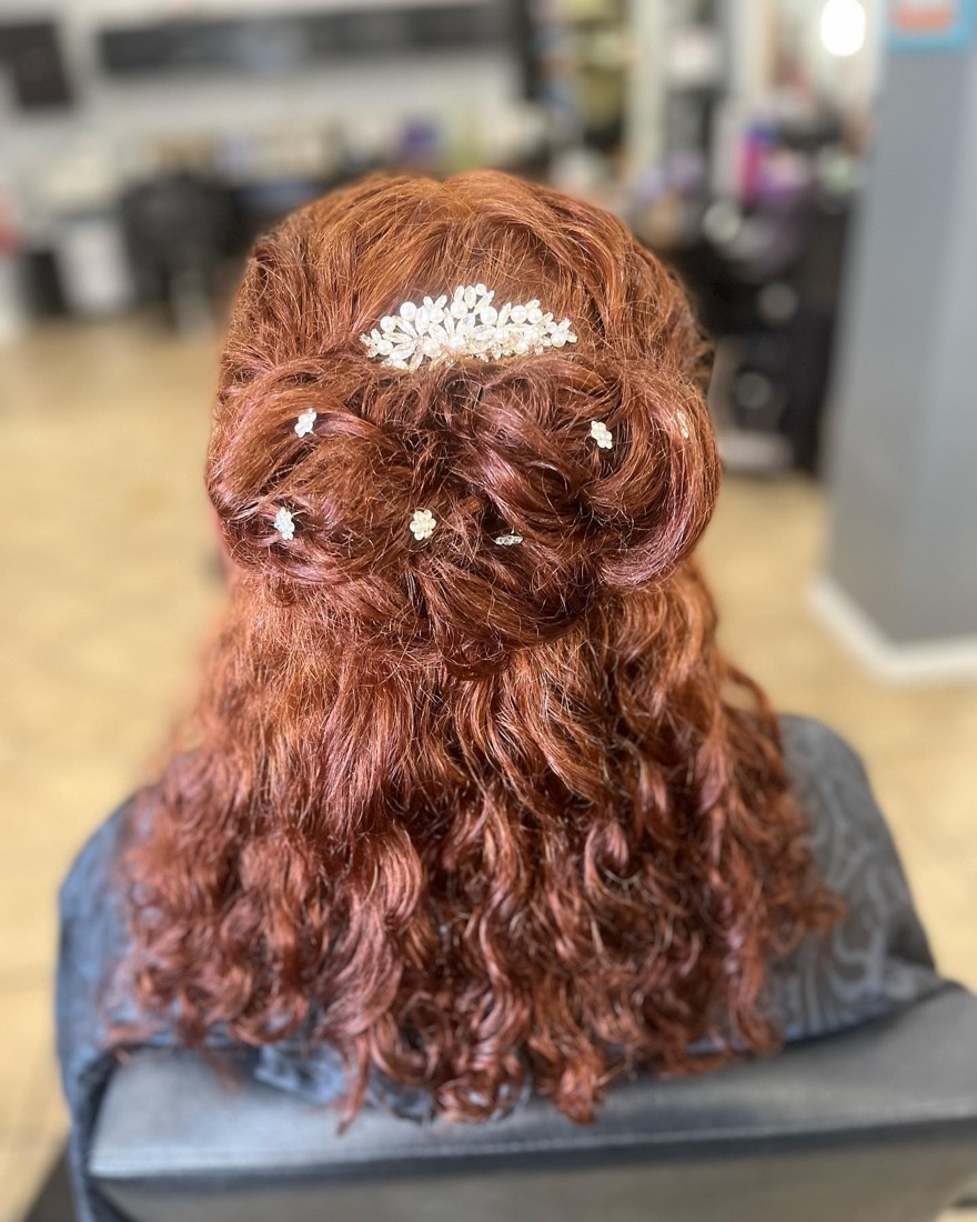 Auburn curls in a formal updo with pearl pins