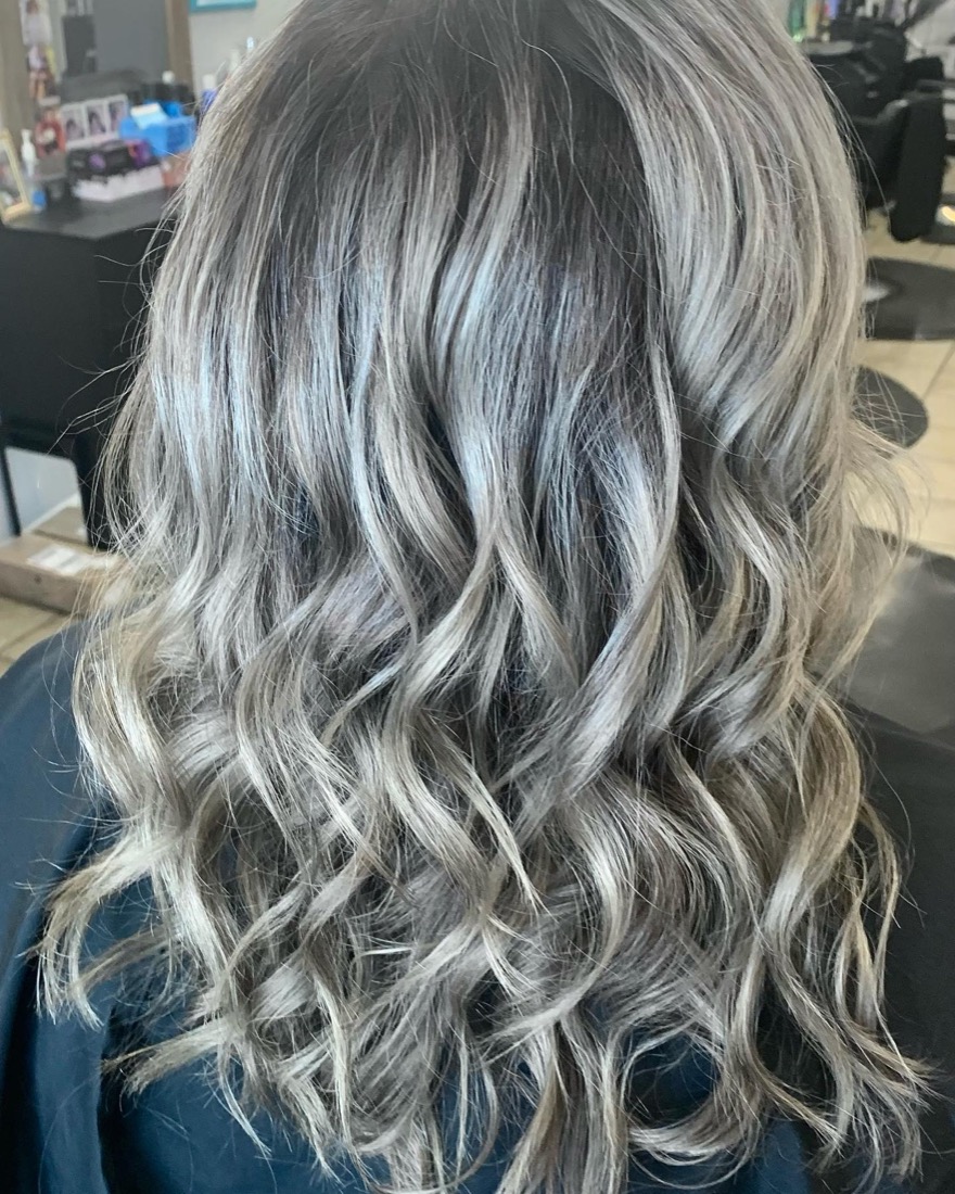 Silver ash-blonde waves colored at Ocean Curls Salon